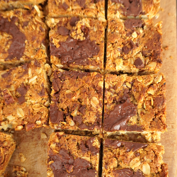 Estas barritas de mantequilla de maní, coco y avena están llenas de sabor y puedes comerlas crudas o cocidas! ¡Déjame te explico! Si te gustan las barritas con una textura más pegajosa o chewy, entonces puedes comerlas sin llevarlas al horno, pero si buscas una textura más crocante, casi como una galleta entonces llevalas al horno por unos 15 minutos y listo! Tu eliges cómo comerlas!